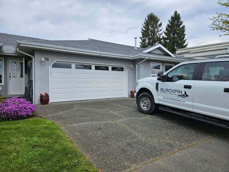Truck on residential driveway featuring a garage door