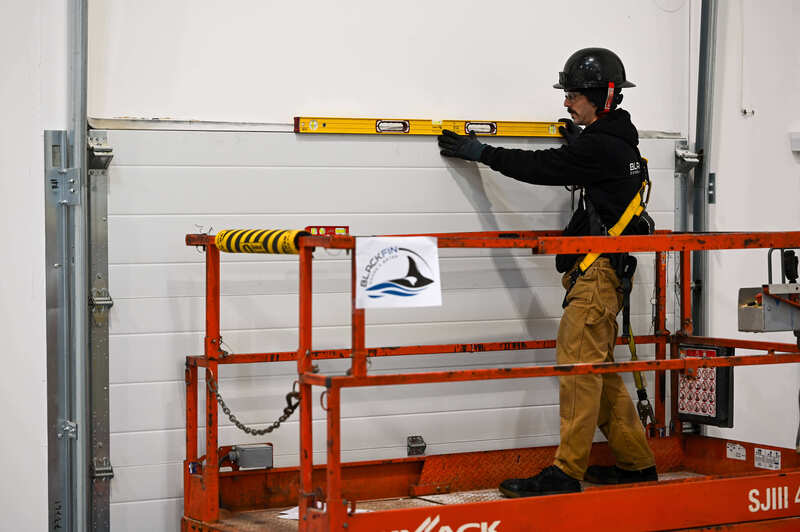 Installer checking the level of a garage door